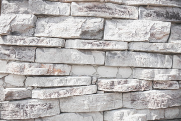 gray wall background of uneven brickwork stone texture.