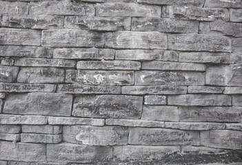 gray wall background of uneven brickwork stone texture.