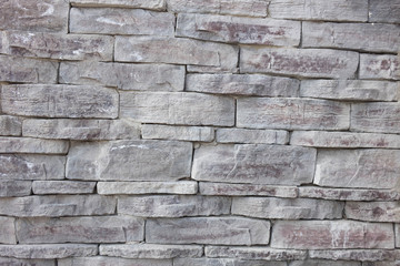 gray wall background of uneven brickwork stone texture.