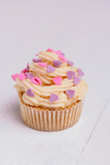 Delicious cupcake on white wooden table close-up