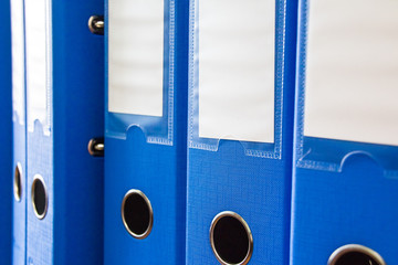 Office folders isolated . Row of blue office folders with blank labels on desk.Files and documents...