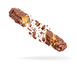Waffle chocolate bar with nuts crushed in the air, isolated on a white background