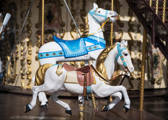 Fototapeta na wymiar A white wooden horse on a merry-go-round