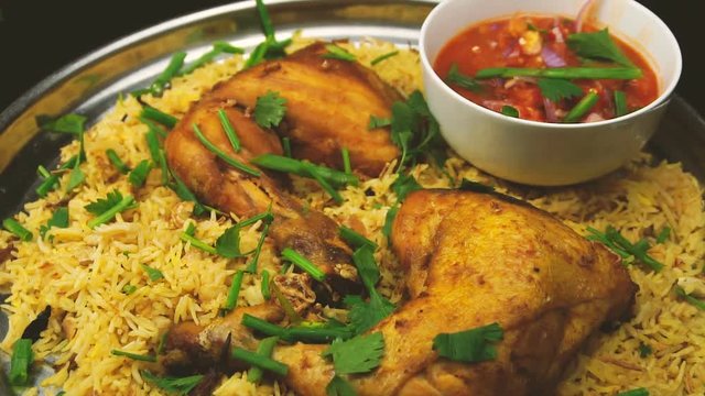 slow motion of spreading parsley on chicken arab kabsah rice