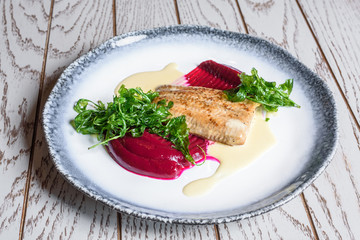 Delicious mediterranean seafood. Fish with green salad on a white plate