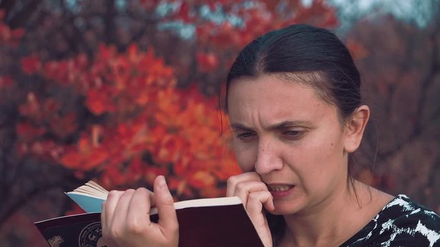 The girl of European appearance conducts an orchestra of trees and leaves of the autumn forest Girl of the European appearance stands face to the autumn forest in the headphones and conducting the orc