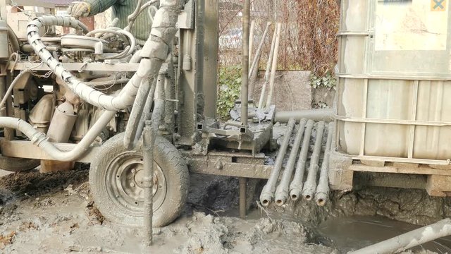 Strange dirty machine makes a well in clay