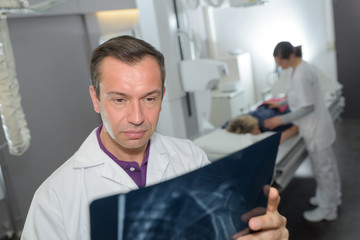 Naklejka na ściany i meble male doctor or surgeon with x-ray at hospital