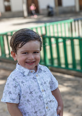 Portrait of a friendly little boy smiling very happy while he is in a park