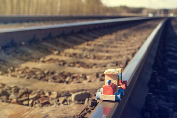 Children's wooden train on the railway, soft focus, toned