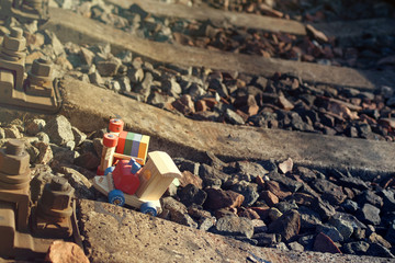 Children's wooden train turned over on the railway. The danger of children's games on the railway.