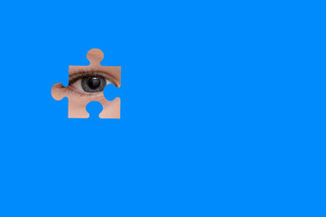 Kid spies through a blue puzzle. Symbol of autism awareness