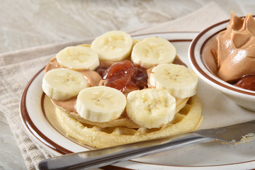 Waffles with peanut butter, jam and banana