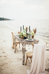 Table set for wedding or another catered event dinner. wedding decoration, decorated table, candle, cake, beautiful tableware, black, golden and rosy color