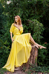 Obraz na płótnie Canvas Young and beautiful girl in a charming yellow dress. Fashion shooting, professional makeup.