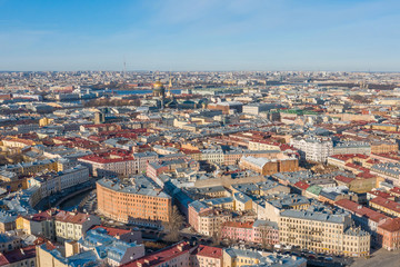 Fototapeta na wymiar Aerial view roofs of old houses in the center of St. Petersburg, in the distance St. Isaac's Cathedral, Peter-Pavel's Fortress.