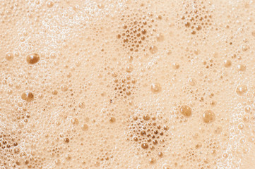 Desktop wallpaper of a computer or a phone made of frothy foam with blobs from morning coffee with milk or cream