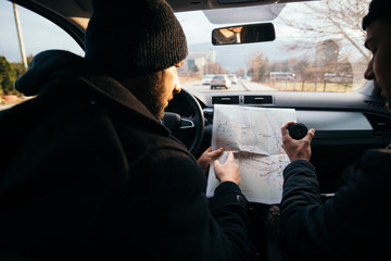 Two Robbers looking at a map and planning their next robbers,one of them is holding a gun.