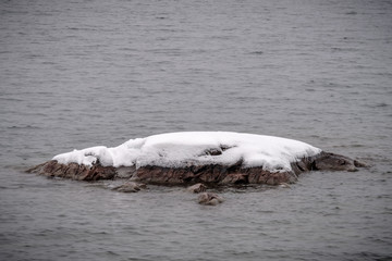 flat stones in the water with snow on top