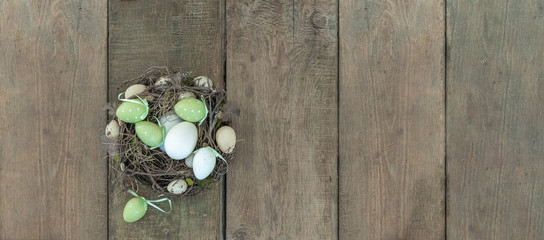 erfrischendes Osternest auf natürlichen Holzdielen im Breitbildformat als Werbehintergrund