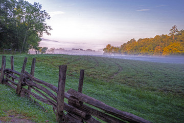 Fog lies over the fields of Cades Cove early in the morning.
