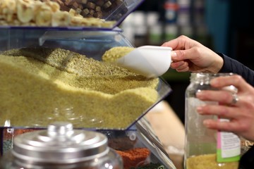 Personne se servant des légumes secs en vrac dans un bocal
