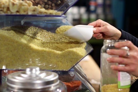 Personne se servant des l&eacute;gumes secs en vrac dans un bocal
