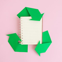 Flat lay of notebook and recycle icon made of paper abstract. Space for copy.