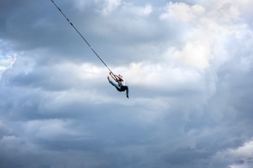 Rope jumping from high altitude bridge. Concept of overcoming fear, courage, active lifestyle,...