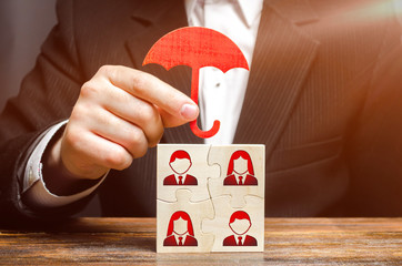 The businessman insures and protects the business team of employees. Team insurance, protection....