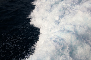 Dark blue sea waves with a lot of sea foam. Scene looked from above.