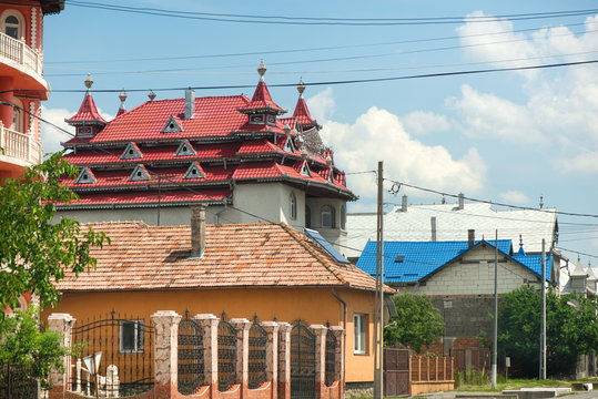 District for rich people with traditional, large gypsy house with luxury decorations and ornaments on the roof in Huedin, Romania. Houses being under construction. 