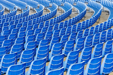 Fototapeta premium Rows of blue plastic chairs on a metal base in rows around the circle in the hall for business presentations