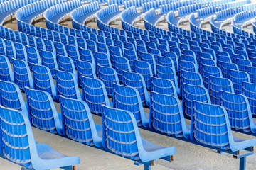 Fototapeta premium Rows of blue plastic chairs on a metal base in rows around the circle in the hall for business presentations