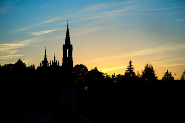 Naklejka premium Silhouette of church and city on sunset or sunrise background. 