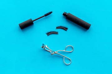 female desk with decorative cosmetic on blue background flatlay