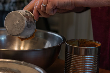 dumping pumpkin puree out into a silver bowl