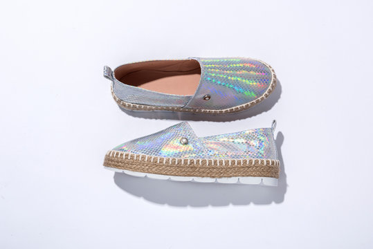 Alpargatas color plata y efecto tornasol sobre fondo blanco