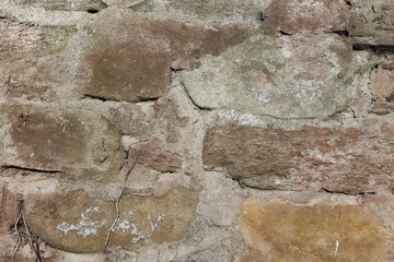 Hintergrundbild einer alten grauen Mauer aus Stein mit vielen Spalten, Rissen und Fugen 