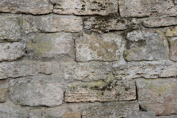 Hintergrundbild einer alten grauen Mauer aus Stein mit vielen Spalten, Rissen und Fugen 