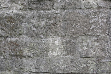 Hintergrundbild einer alten grauen Mauer aus Stein mit vielen Spalten, Rissen und Fugen 