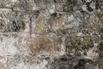Hintergrundbild einer alten grauen Mauer aus Stein mit vielen Spalten, Rissen und Fugen 