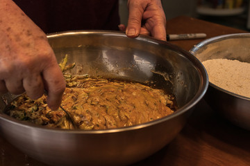 mixing a metal bowl of different ingredients