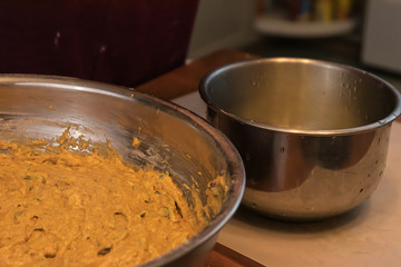 muffin batter in a metal bowl near another bowl