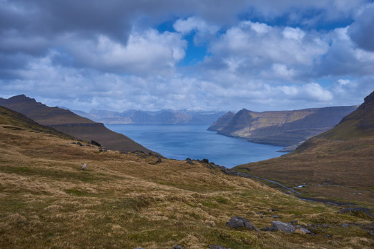Scenic landscape Picture of large and deep fiord or fjord in Faroe island Eysturoy during cloudy morning in spring. Faroe islands in nord atlantic, part of Danish kingdom, pure scandinavian nature.