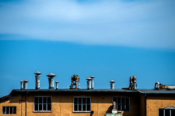 Top of obsolete vintage industrial building and facilities on blue sky background