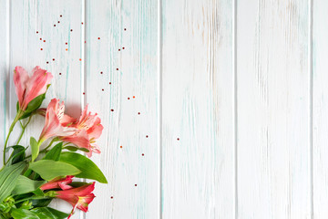Background for text banner on a dark wooden background with pink flowers. Blank, frame for text. Greeting card design with flowers. Aalstroemeria on wooden background. View from above