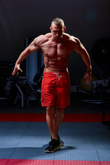 Fototapeta na wymiar Athletic man posing. Photo of man with perfect physique on black background. Strength and motivation