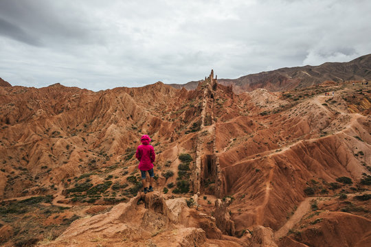 female hiker with purple jacket in bizzare mountain landscape, kyrgyzstan