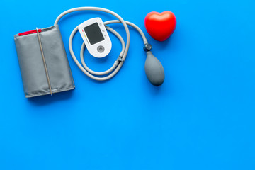 pulsimeter on the desk of the doctor for diagnostics of cardiac disease on blue background top view space for text